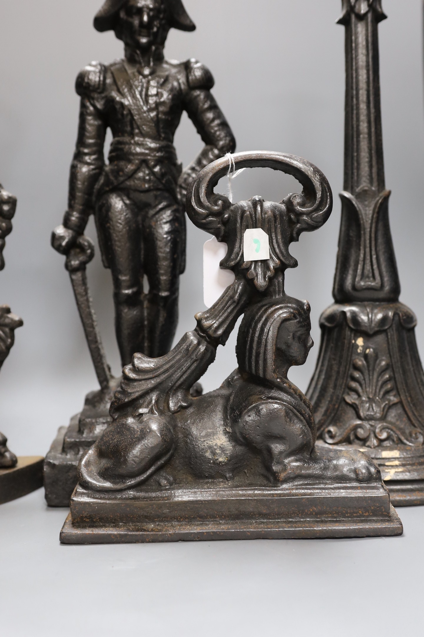 A cherubic cast iron door stop, another of Napoleon, a sphinx and another,(4), Napoleon 40 cms high